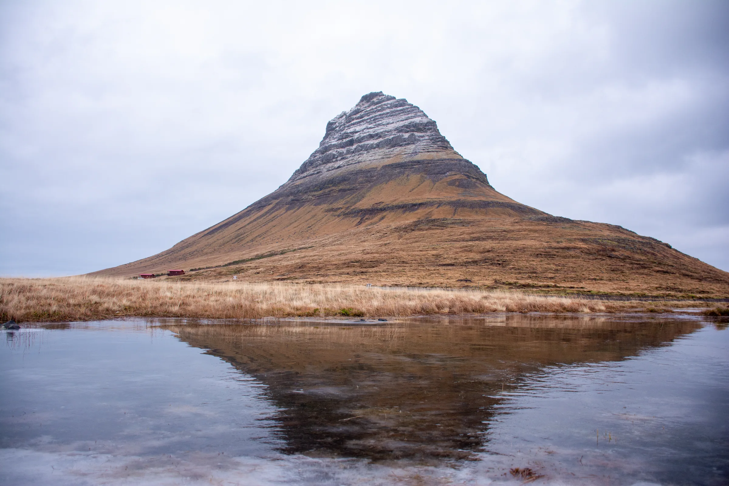 La montaña Kirkjufell reflejada en el agua durante un viaje grupal a Islandia
